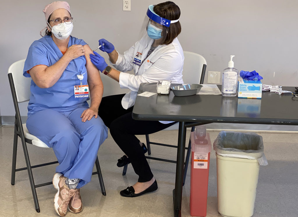 A doctor receives a vaccine shot at Dominican Hospital in late 2020