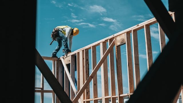 Construction worker builds frame of house