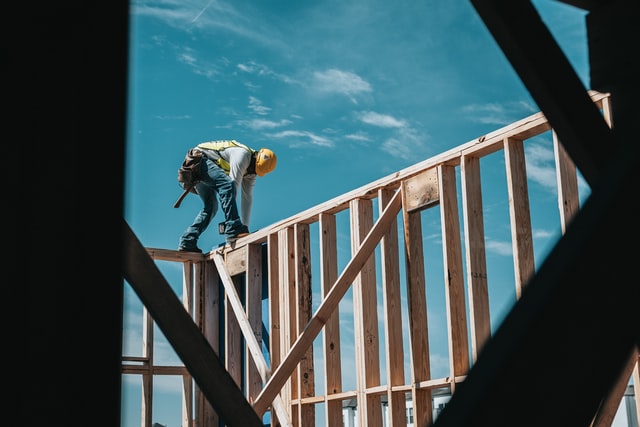 Construction worker builds frame of house