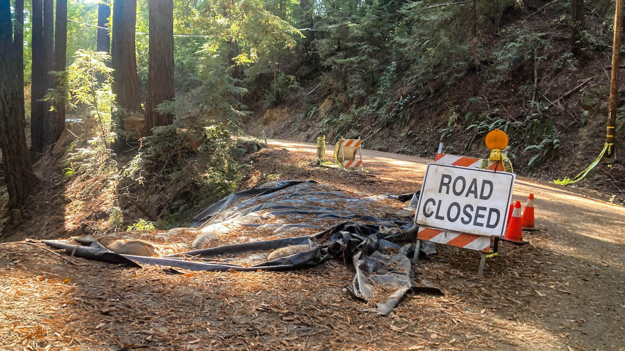 A sandwich-board sign reads "ROAD CLOSED" on Shulties Road in October 2023 after winter storms at the beginning of the year caused a sinkhole.