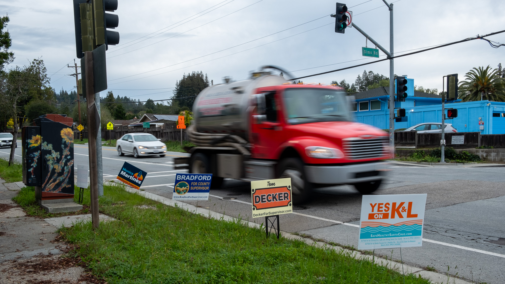 A truck whizzes past signs for District 5 supervisor candidates on Graham Hill Road.