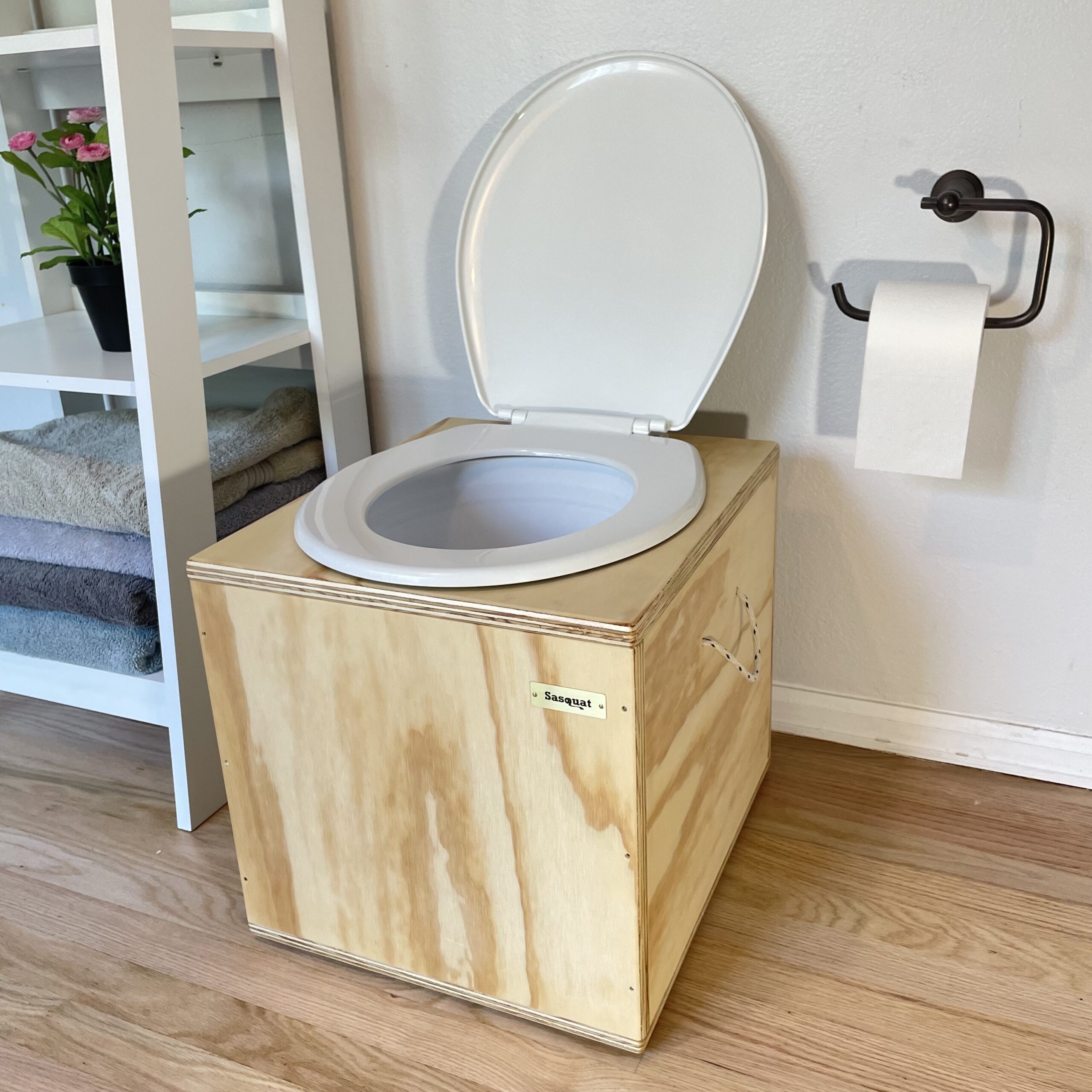 A compost toilet with a toilet set on top of a wooden box.