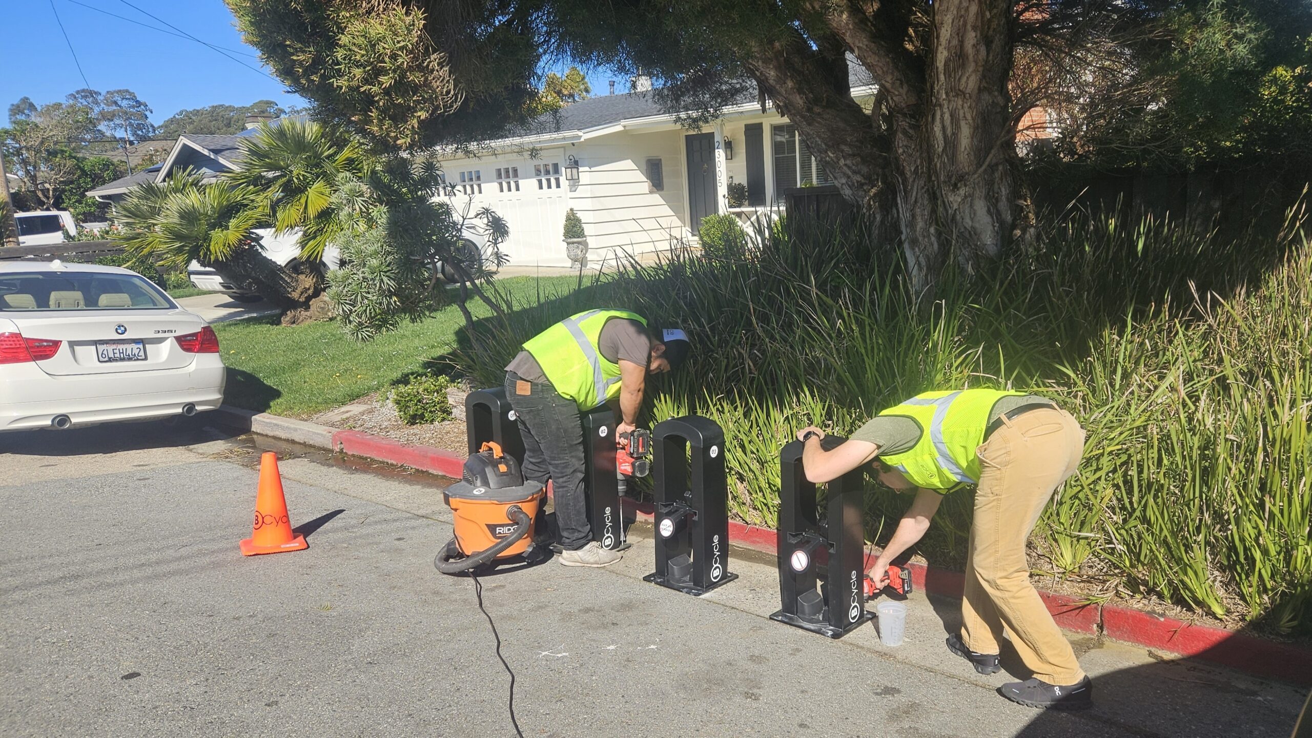 BCycle Dock Technician Edgar Espino and General Manager Kyle Klein install racks for BCycle electric rental bikes on East Cliff Drive at 32nd Avenue on Wednesday. (Tyler Maldonado — Santa Cruz Local)
