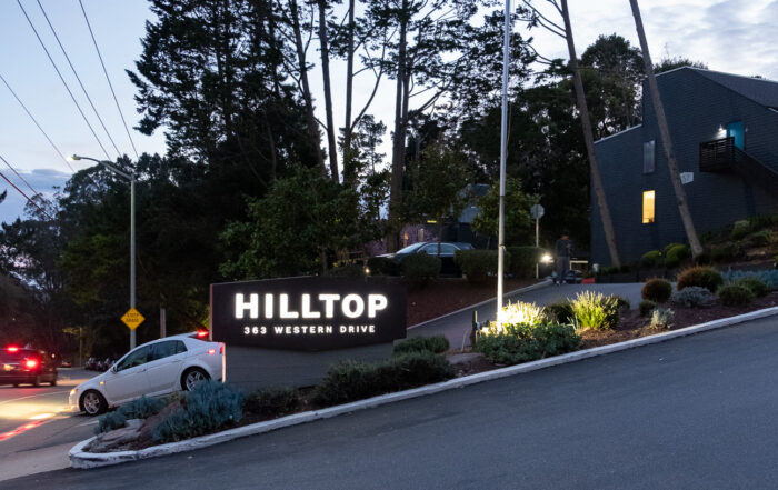 An illuminated sign for the Hilltop apartments in Santa Cruz is seen just after sunset in February 2025.