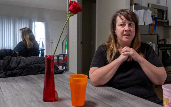 Hilltop Melissa Scalia sits at her kitchen table with one elbow on the table.