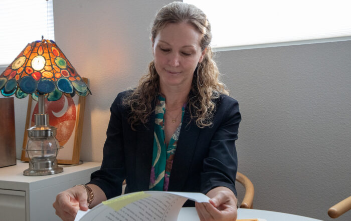 Santa Cruz County Public Defender Heather Rogers sits at her desk looking at a case file.